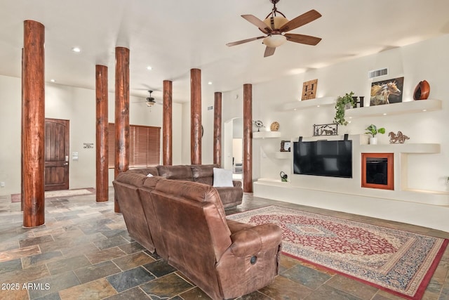 living room with ceiling fan and decorative columns