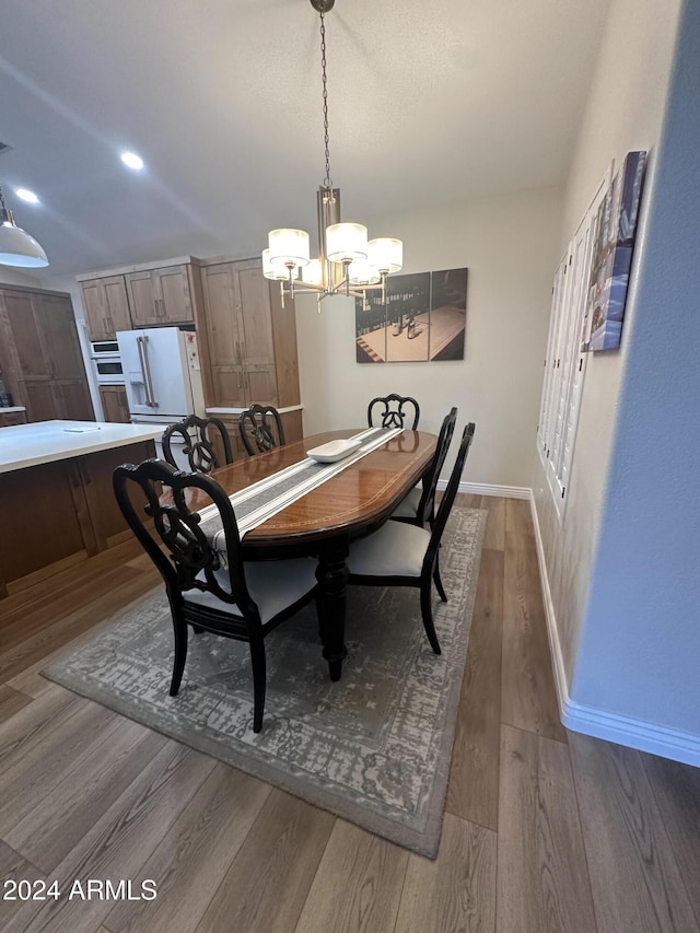 dining room with dark hardwood / wood-style floors and an inviting chandelier