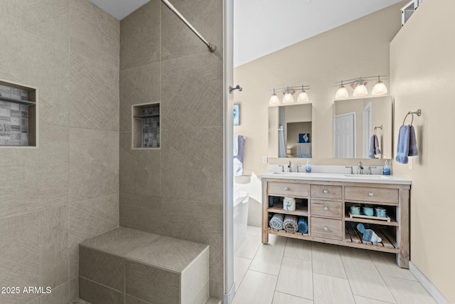 bathroom featuring double vanity, tiled shower, a sink, and tile patterned floors