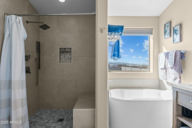 bathroom featuring a freestanding tub, a tile shower, and vanity