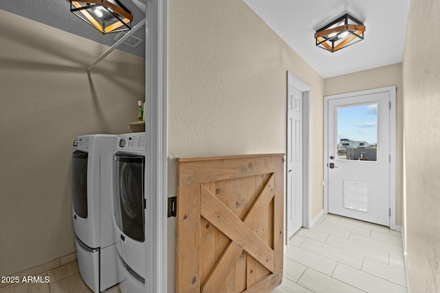 laundry room featuring laundry area, washing machine and clothes dryer, and baseboards