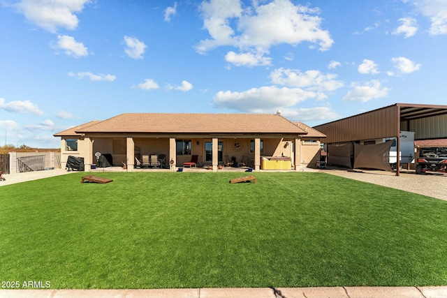 exterior space featuring a patio area, a lawn, a hot tub, and fence