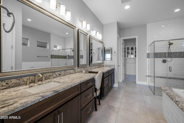 full bath featuring a stall shower, a bathing tub, vanity, and tile patterned floors