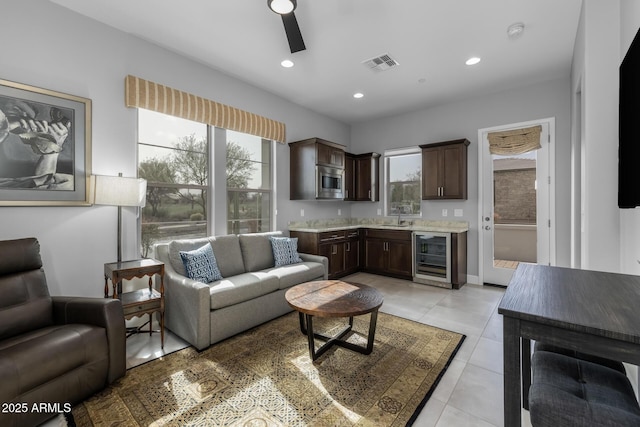 living room with light tile patterned floors, beverage cooler, visible vents, ceiling fan, and recessed lighting