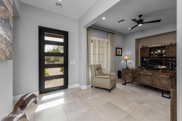 foyer entrance with a ceiling fan, visible vents, baseboards, and light tile patterned floors