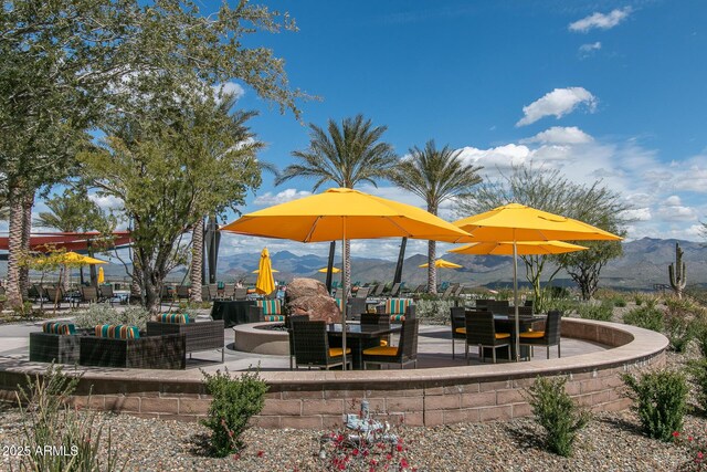 view of community with a mountain view, a fire pit, and a patio