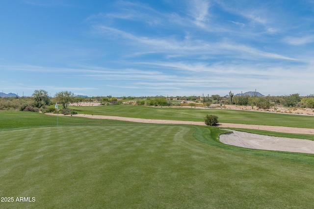 view of property's community featuring view of golf course and a yard