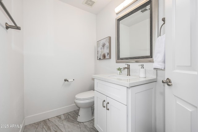 bathroom featuring toilet, vanity, visible vents, baseboards, and marble finish floor