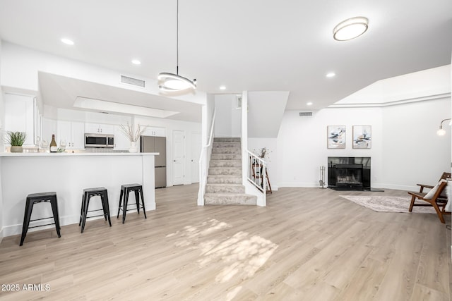 kitchen featuring light wood-style floors, white cabinetry, visible vents, and stainless steel appliances