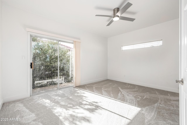 carpeted spare room featuring ceiling fan