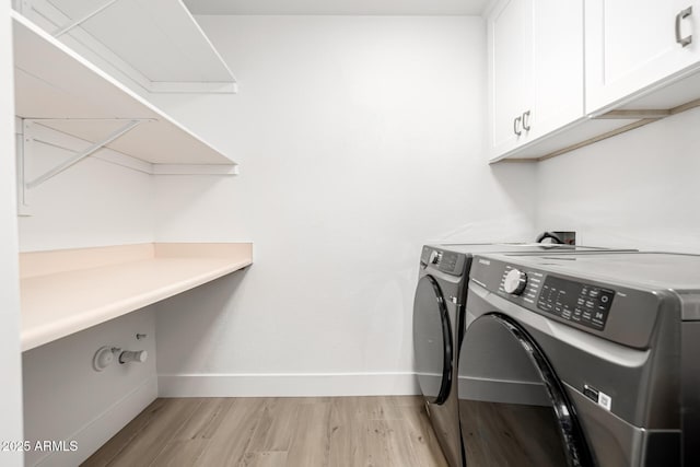 laundry area with cabinet space, independent washer and dryer, light wood-style flooring, and baseboards