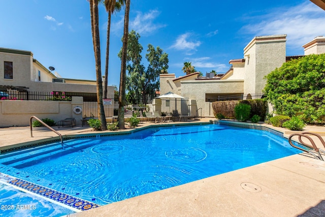 community pool featuring a patio area and fence