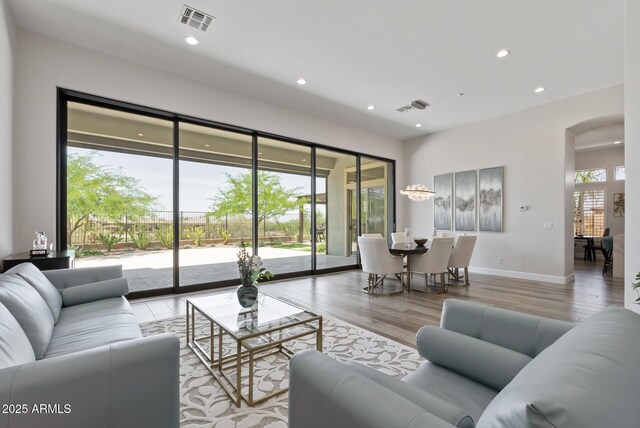 3045 W Feather Sound Dr, Phoenix, AZ 85086 - living room with arched walkways, wood finished floors, recessed lighting, and baseboards