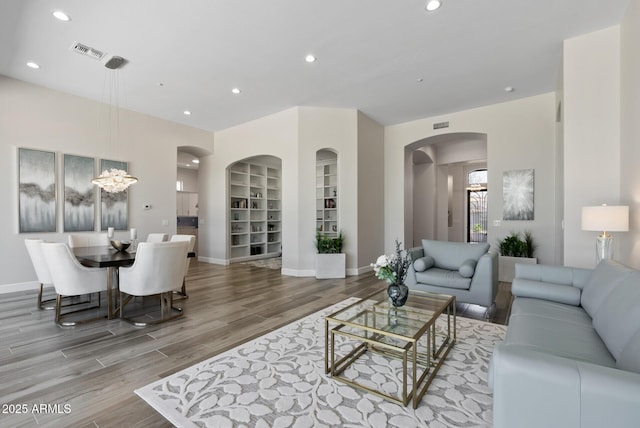 3045 W Feather Sound Dr, Phoenix, AZ 85086 - living room featuring wood finished floors, arched walkways, recessed lighting, baseboards, and built in shelves