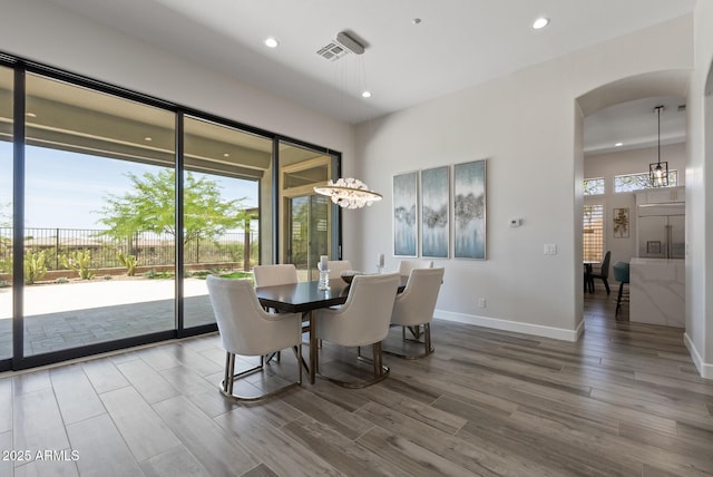 3045 W Feather Sound Dr, Phoenix, AZ 85086 - dining room with arched walkways, wood finished floors, recessed lighting, a chandelier, and baseboards