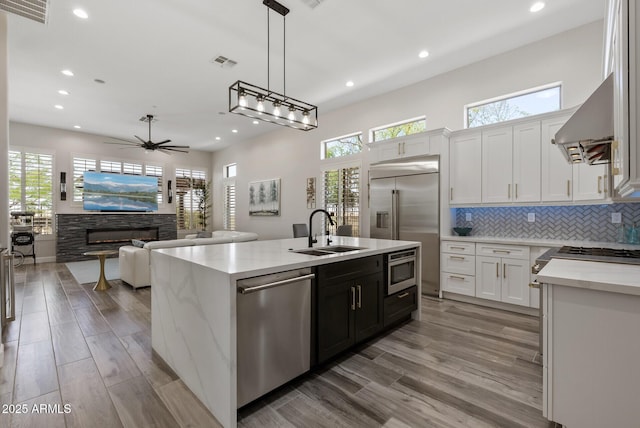 3045 W Feather Sound Dr, Phoenix, AZ 85086 - kitchen with built in appliances, a sink, recessed lighting, white cabinets, and a center island with sink