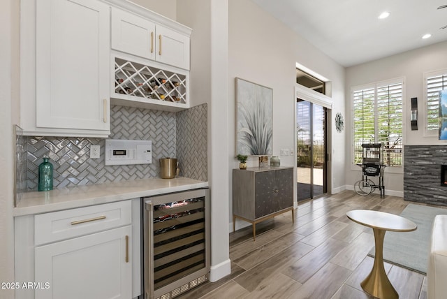 3045 W Feather Sound Dr, Phoenix, AZ 85086 - indoor dry bar featuring wine cooler, decorative backsplash, light wood-style flooring, baseboards, and recessed lighting