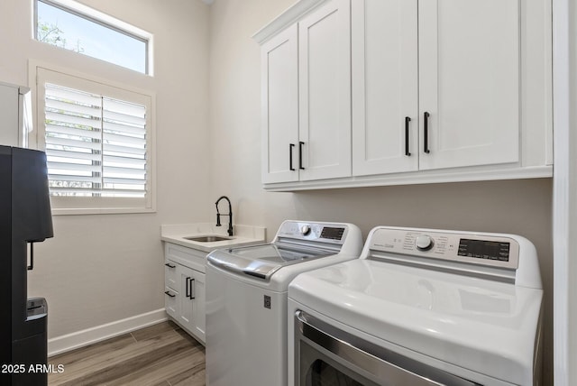 3045 W Feather Sound Dr, Phoenix, AZ 85086 - washroom featuring washer and dryer, healthy amount of natural light, cabinet space, and wood finished floors