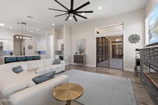 3045 W Feather Sound Dr, Phoenix, AZ 85086 - living area with ceiling fan, wood finished floors, a glass covered fireplace, recessed lighting, and baseboards