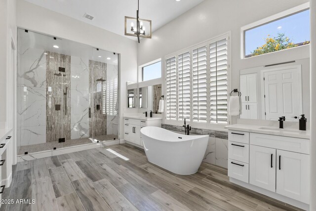 3045 W Feather Sound Dr, Phoenix, AZ 85086 - bathroom featuring a marble finish shower, two vanities, a freestanding tub, a chandelier, and a towering ceiling