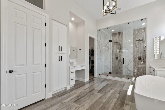 3045 W Feather Sound Dr, Phoenix, AZ 85086 - bathroom featuring a marble finish shower, a freestanding tub, a spacious closet, a chandelier, and wood finished floors