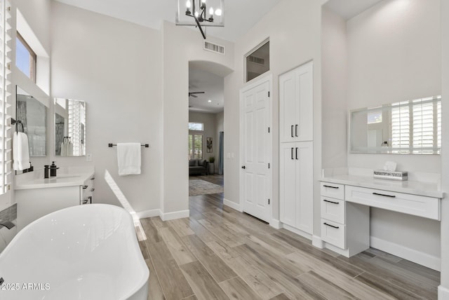 3045 W Feather Sound Dr, Phoenix, AZ 85086 - bathroom with a freestanding bath, vanity, wood finished floors, a chandelier, and a ceiling fan