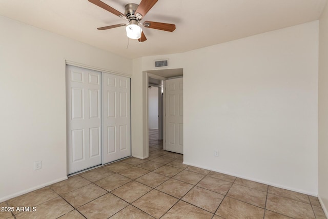 17244 N 36th Ln, Glendale, AZ 85308 - unfurnished bedroom with a closet, light tile patterned floors, baseboards, and ceiling fan