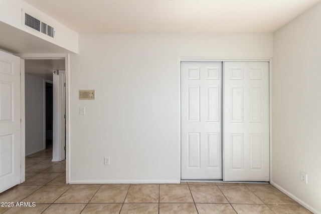 17244 N 36th Ln, Glendale, AZ 85308 - unfurnished bedroom with light tile patterned floors, a closet, and baseboards
