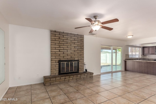 17244 N 36th Ln, Glendale, AZ 85308 - unfurnished living room with light tile patterned flooring, a brick fireplace, and ceiling fan