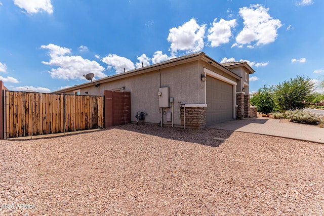 16221 W Prickly Pear Trl, Surprise, AZ 85387 - view of property exterior with concrete driveway, an attached garage, and stone siding