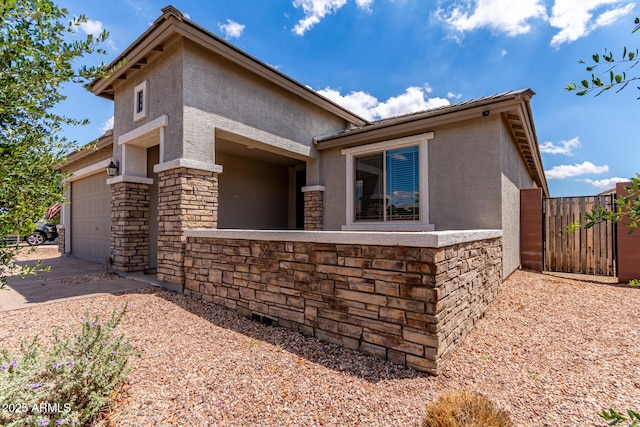 16221 W Prickly Pear Trl, Surprise, AZ 85387 - view of home's exterior featuring stucco siding, stone siding, an attached garage, and concrete driveway