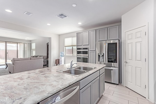 16221 W Prickly Pear Trl, Surprise, AZ 85387 - kitchen with stainless steel appliances, a sink, gray cabinetry, recessed lighting, and open floor plan