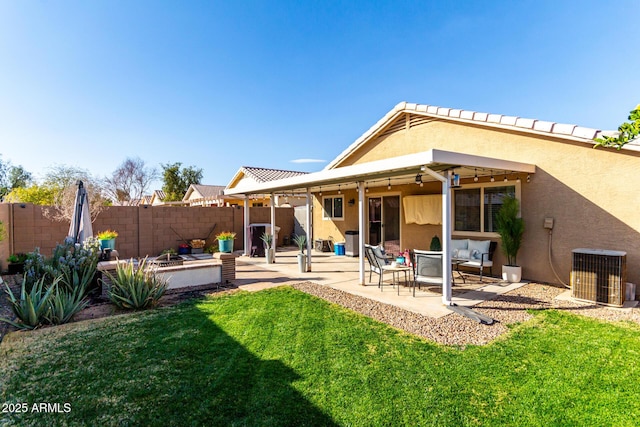 rear view of property with cooling unit, a patio area, and a yard