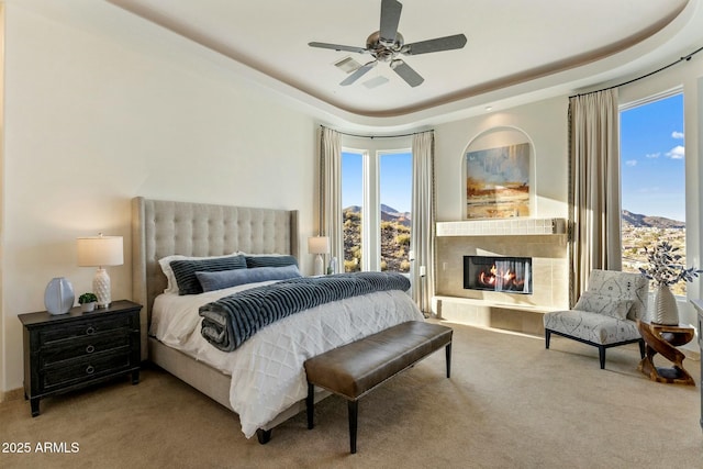 11320 N Crestview Dr, Fountain Hills, AZ 85268 - carpeted bedroom featuring a tile fireplace, a ceiling fan, and a raised ceiling