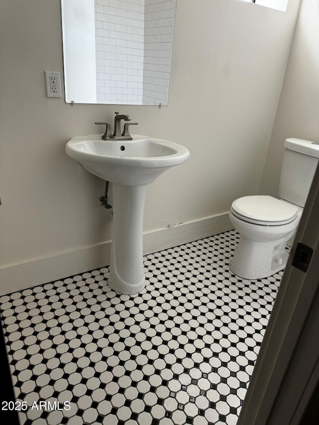 bathroom featuring baseboards and toilet