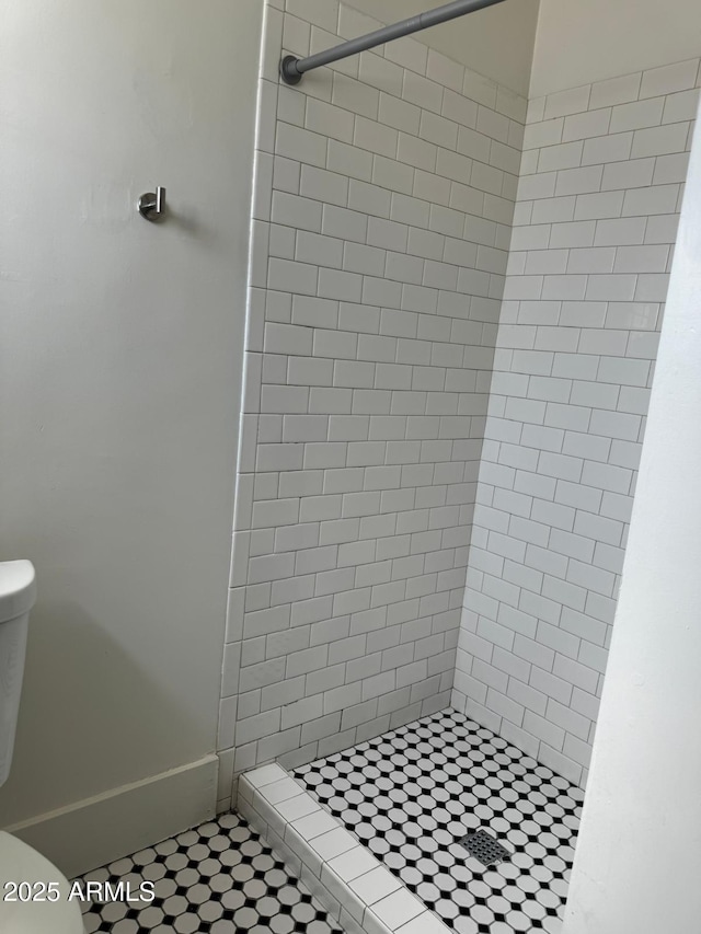 bathroom with a shower stall, tile patterned flooring, and toilet