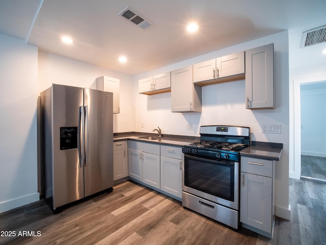 kitchen with gray cabinetry, stainless steel appliances, visible vents, and a sink