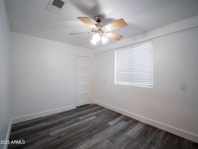 spare room featuring ceiling fan, baseboards, dark wood-style floors, and visible vents