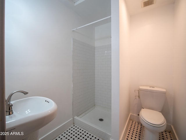 full bath featuring a sink, toilet, visible vents, a shower stall, and baseboards