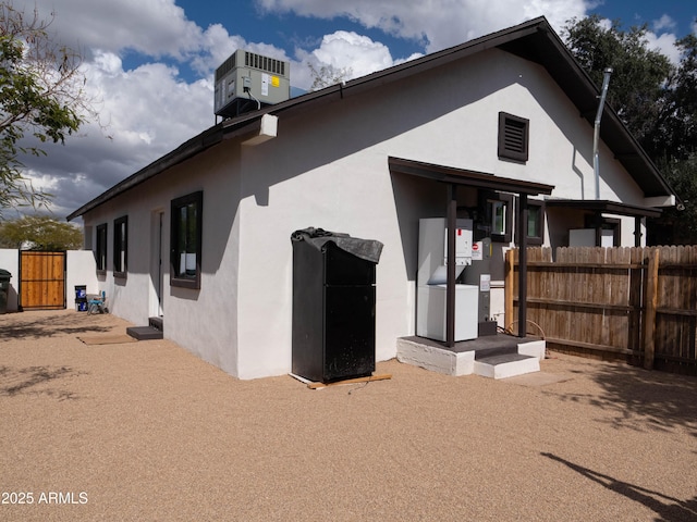 back of house featuring fence and stucco siding