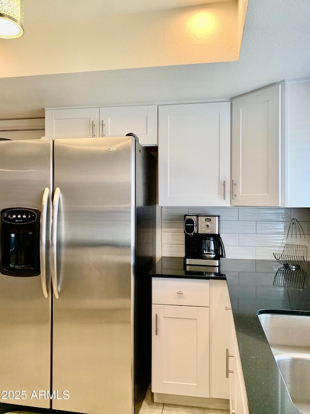 kitchen with white cabinetry, stainless steel fridge, and sink