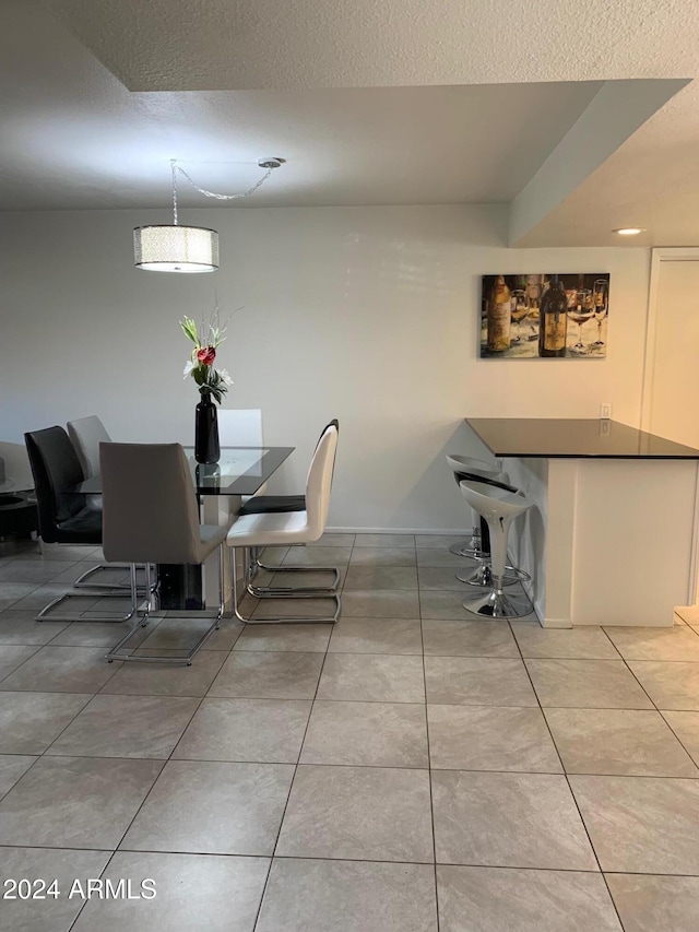 tiled dining area with a textured ceiling