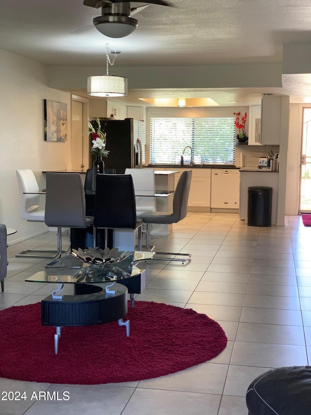 living room with sink, light tile patterned floors, and a textured ceiling