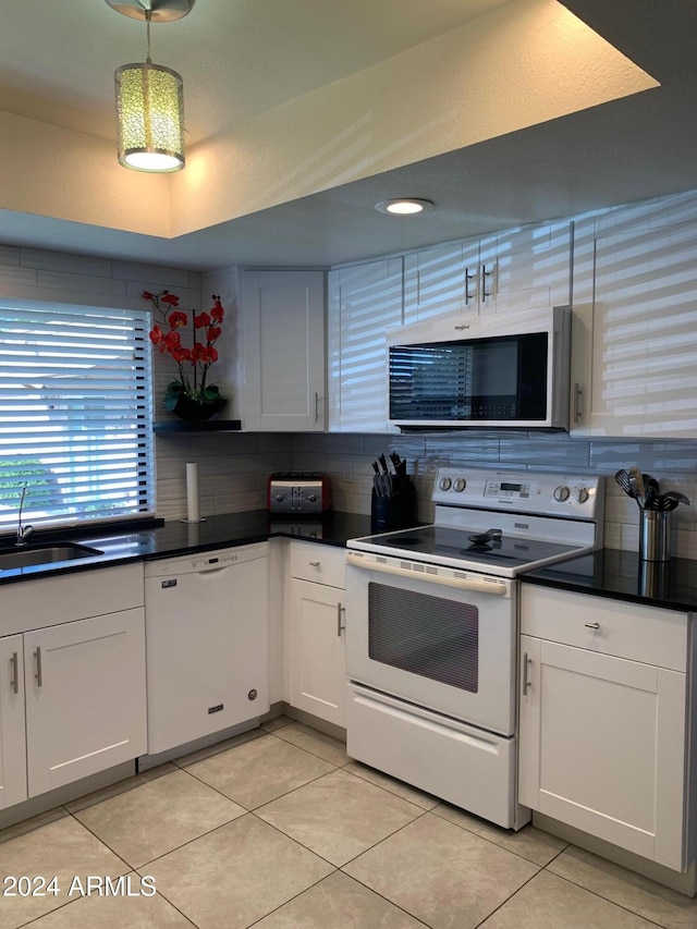 kitchen with white cabinetry, white appliances, sink, and hanging light fixtures