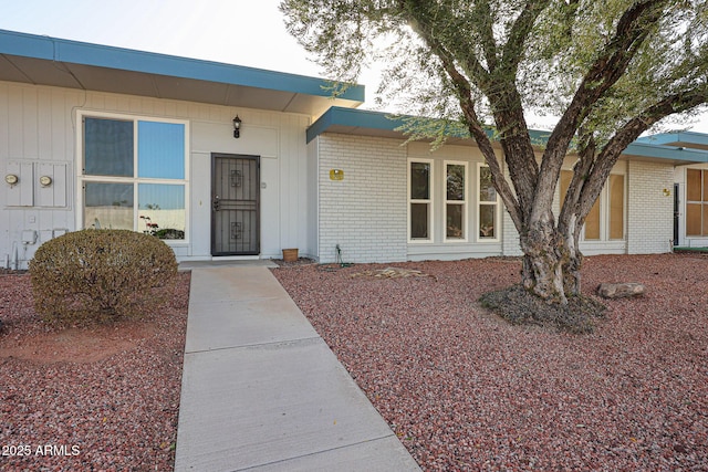 entrance to property featuring brick siding