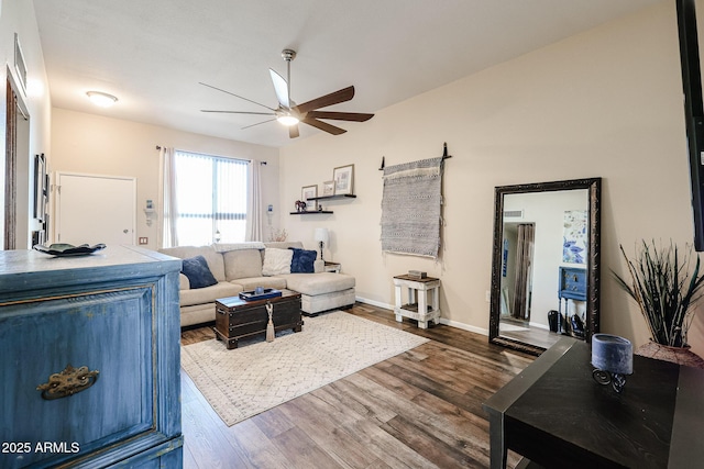 living room with baseboards, a ceiling fan, and wood finished floors