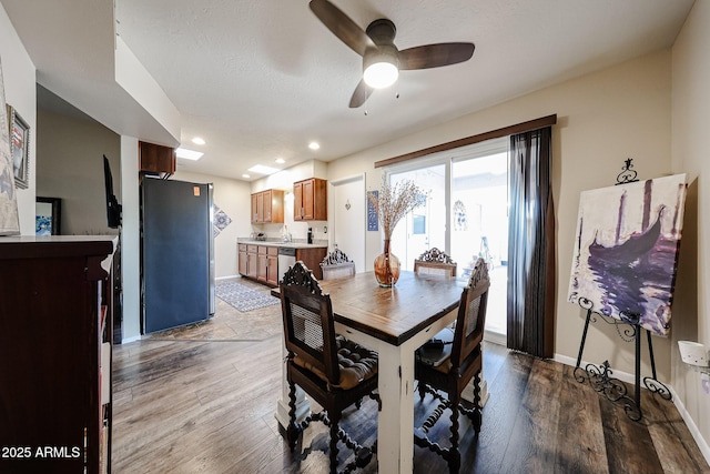 dining room with baseboards, ceiling fan, wood finished floors, a textured ceiling, and recessed lighting