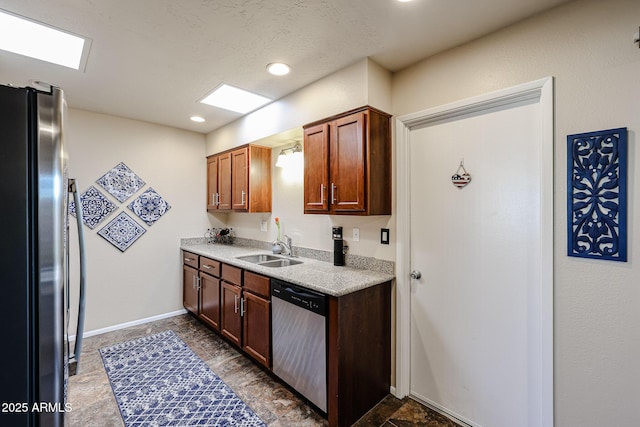 kitchen featuring baseboards, appliances with stainless steel finishes, light countertops, a sink, and recessed lighting