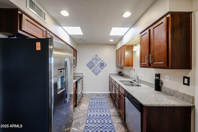 kitchen featuring recessed lighting, stainless steel appliances, a sink, visible vents, and baseboards