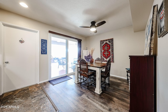 dining space with dark wood-style floors, ceiling fan, a textured ceiling, and baseboards